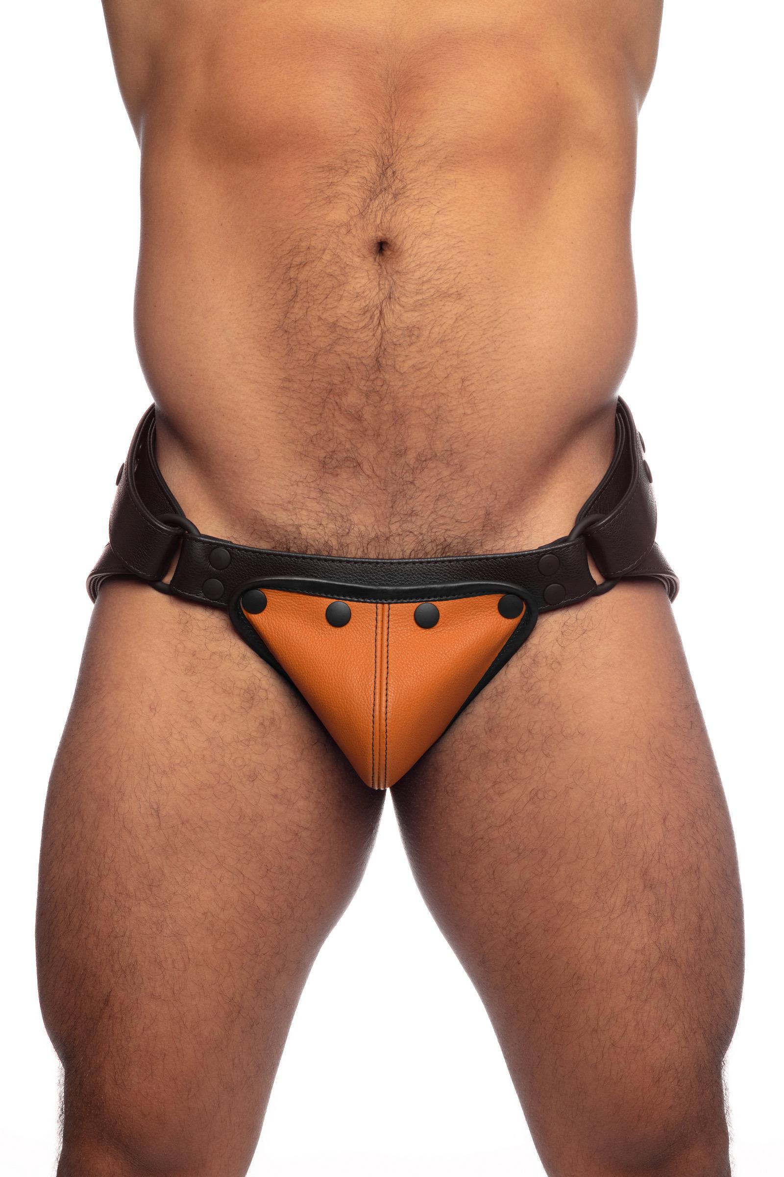 Male model in a black leather jockstrap with orange codpiece. Front view.