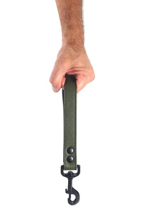 Male model holding a 1-inch-wide Australian-made ARMY OF MEN leather HANDLE LEASH - Army Green, with matte black hardware.