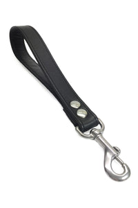 ARMY OF MEN 1-inch-wide black leather handle leash with stainless steel rivets, and snap hook, laid flat and shot from above.