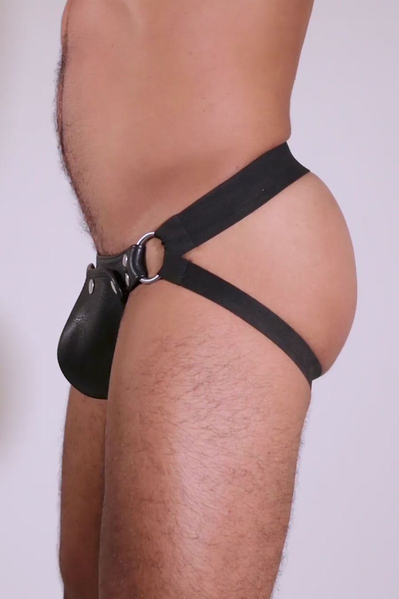 Male model in an ARMY OF MEN black elastic and leather jockstrap with stainless steel hardware.