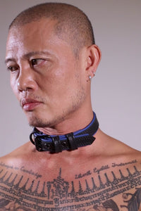 Model removing a 1" wide black and blue leather Combat Collar Narrow