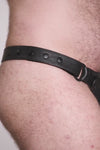 Video of a model wearing a black leather thong with a black harness codpiece. Matt black hardware