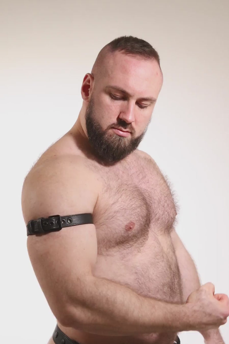 Video of a model wearing a 1" wide black leather armband belt with matt black hardware