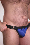 Video of a model wearing a black leather thong with a blue codpiece. Matt black hardware.