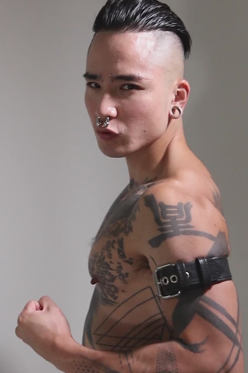 Model wearing a 1.5" black leather combat armband belt with stainless steel hardware