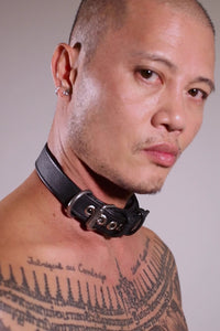 Model removing a 1" wide black leather collar with stainless steel hardware