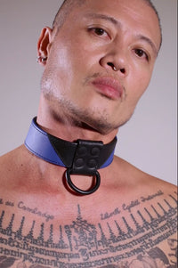 Model removing a 1.5" wide black and blue leather Chevron Collar