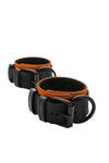Coiled pair of 2.25" wide ARMY OF MEN black and orange leather ankle restraints with matte black metal hardware.