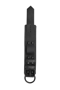 ARMY OF MEN 2.25" wide WRIST RESTRAINTS - Black with matte black rivets, buckle, and D-ring, laid flat and shot from above.