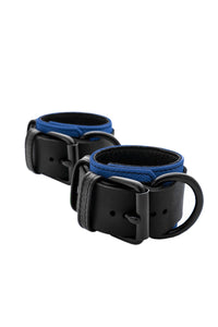 Coiled pair of 2.25" wide ARMY OF MEN WRIST RESTRAINTS - Blue with matte black metal rivets, buckles, and D-rings.