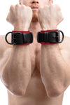 Front-on shot of muscular male model in a pair of 2.25" wide ARMY OF MEN WRIST RESTRAINTS - Red with matte black hardware.