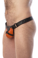 Model wearing a black leather thong with an orange harness codpiece. Matt black hardware. Side view.