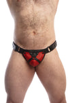 Model wearing a black leather thong with a red harness codpiece. Matt black hardware. Front view.