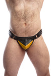 Model wearing a black leather thong with a yellow shadow codpiece. Matt black hardware. Front view.