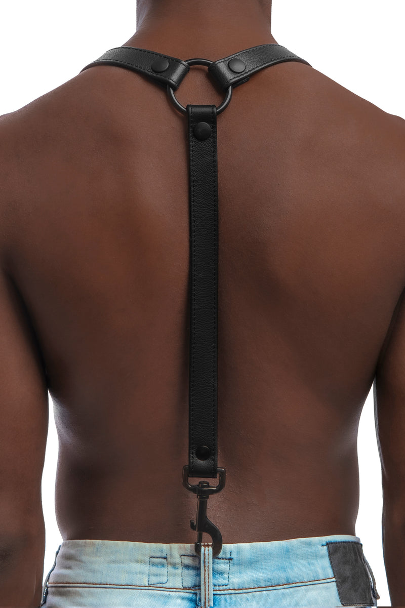 Model wearing black leather braces with black metal hardware attached to jeans. Back 1.