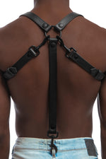 Model wearing black leather braces with black metal hardware as shoulder harness attached to jeans. Back 3.