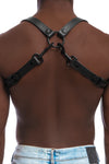 Model wearing black leather braces with black metal hardware as shoulder harness. Back 2.
