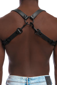 Model wearing black leather braces with black metal hardware as shoulder harness. Back 2.
