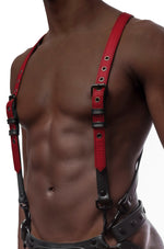 Model wearing red and black leather braces kit with black metal hardware attached to leather jock. Front view.