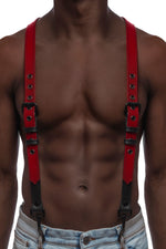 Model wearing red and black leather braces with black metal hardware attached to jeans. Front view.