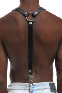 Model wearing black leather braces with stainless steel hardware attached to jeans. Back 1.