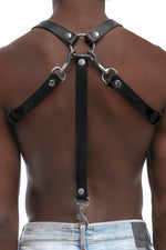 Model wearing black leather braces with stainless steel hardware as shoulder harness attached to jeans. Back 3.