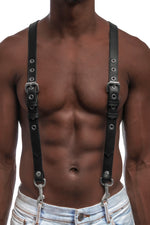 Model wearing black leather braces with stainless steel hardware attached to jeans. Front 1.