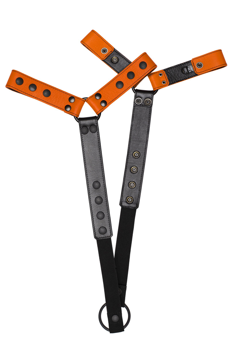 Pair of orange leather bulldog harness connectors with black hardware.