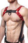 Model wearing a red leather bulldog harness and connector with black hardware. Connector attached to a jockstrap. Side.