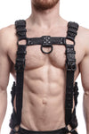 Model wearing a black leather combat harness and connector with black metal hardware, connected to a jock. Front view.