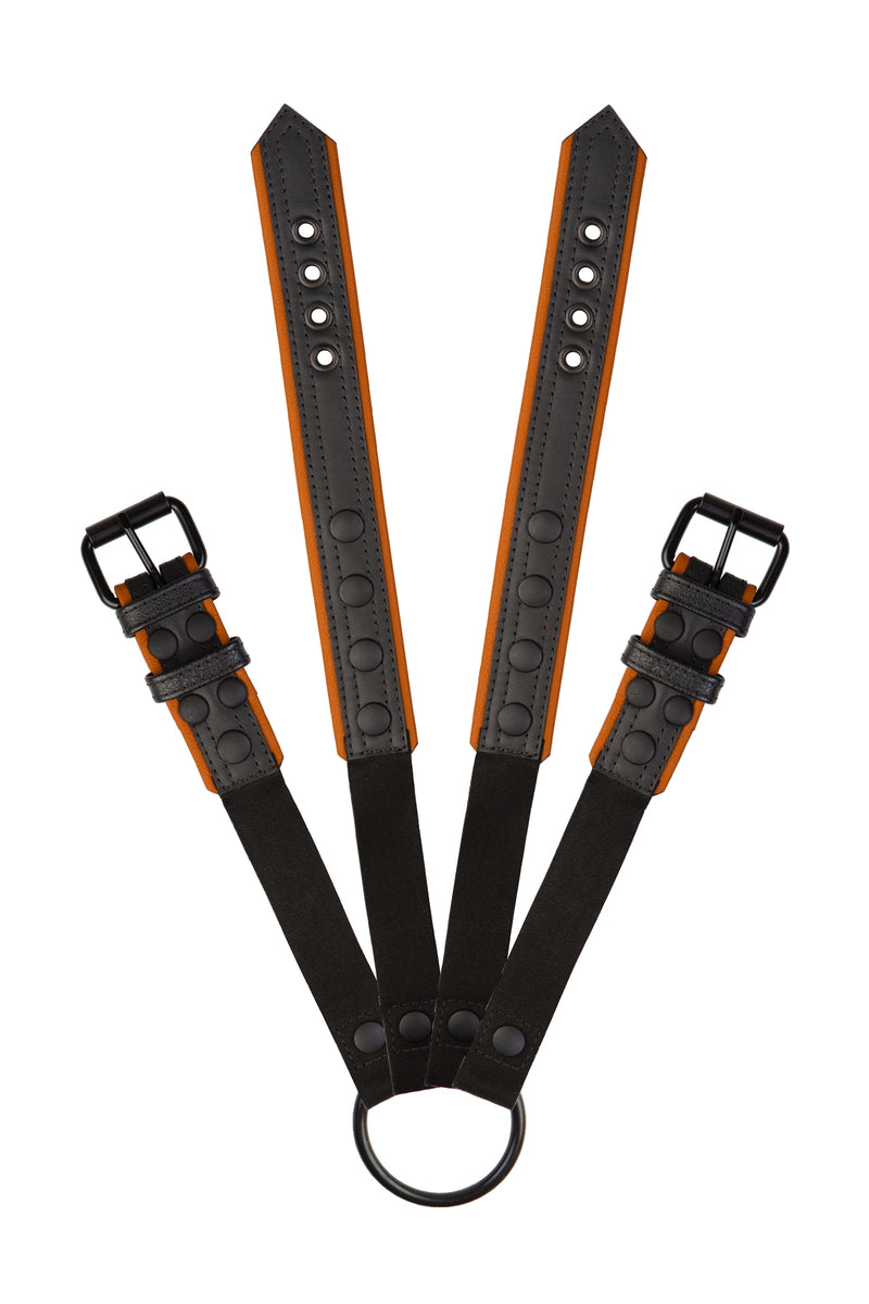 Pair of black and orange leather combat harness connectors with black hardware. Connected. Front view.