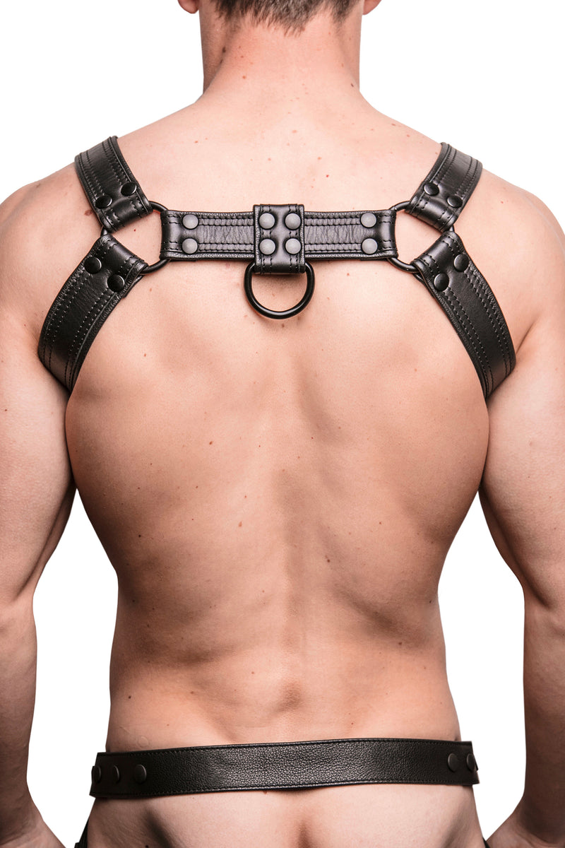 Model wearing black leather combat bulldog harness with matt black metal hardware. Back View.