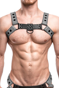 Model wearing a grey leather bulldog harness with black hardware. Front.