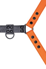 Orange leather bulldog harness with black hardware. Close up.