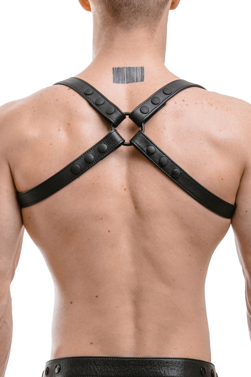 Model wearing black leather shoulder harness with matt black hardware