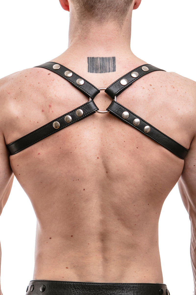 Model wearing black leather shoulder harness with stainless steel hardware