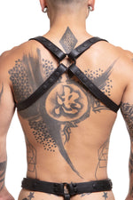 Model wearing black leather shoulder buckle harness with black hardware back view