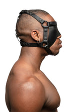 Model wearing black leather head harness and blinder with black metal hardware. Side view.