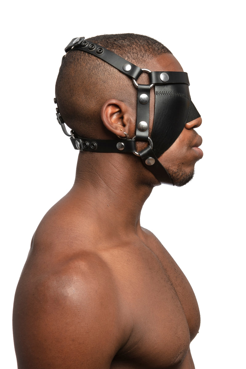 Model wearing black leather head harness and blinder with stainless steel hardware. Side view.