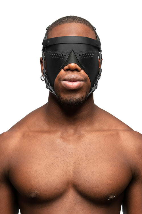 Model wearing black leather head harness and partial blinder with black metal hardware. Front view.