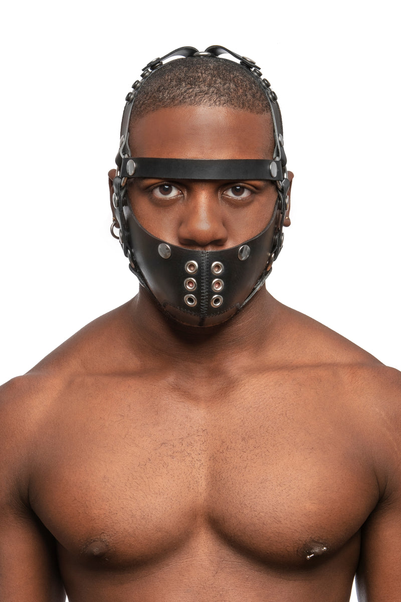 Model wearing black leather head harness and muzzle with stainless steel hardware, front, no nose strap