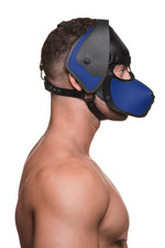 Model wearing a black and blue leather pup mask and head harness side view