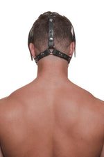 Model wearing a black leather pup mask and head harness with stainless steel hardware back view