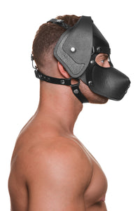 Model wearing a black leather pup mask and head harness with stainless steel hardware side view