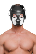 Model wearing a black and white leather pup mask and head harness front view