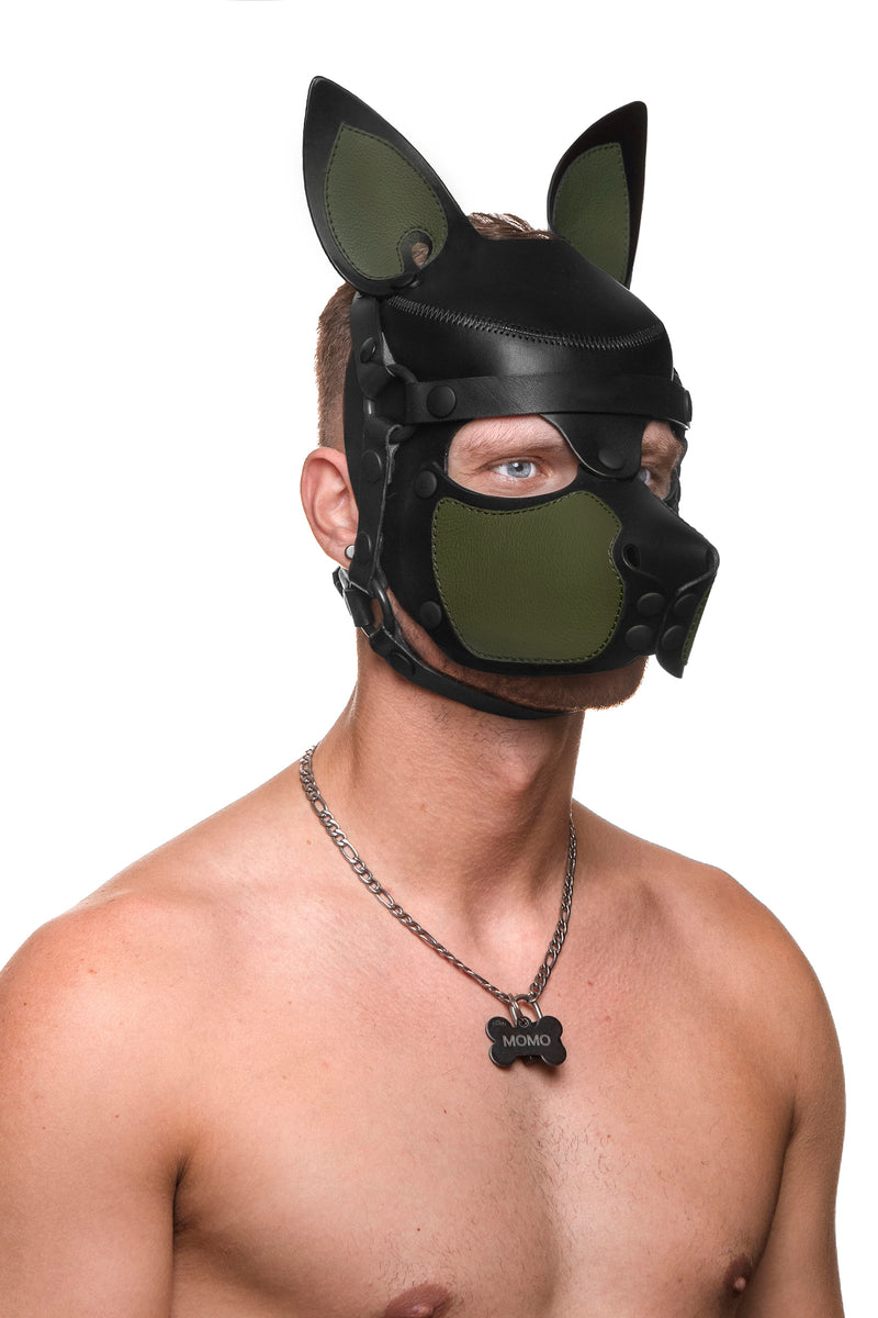 Model wearing a black and army green leather pup mask and head harness three quarter view