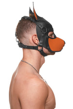 Model wearing a black and orange leather pup mask and head harness side view
