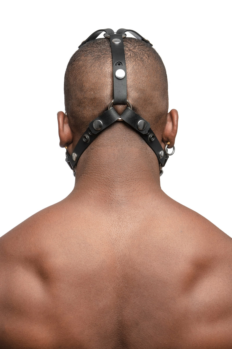 Model wearing black leather head harness with stainless steel hardware, back