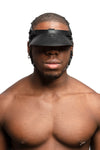 Model wearing black leather head harness and visor with black metal hardware. Front view.