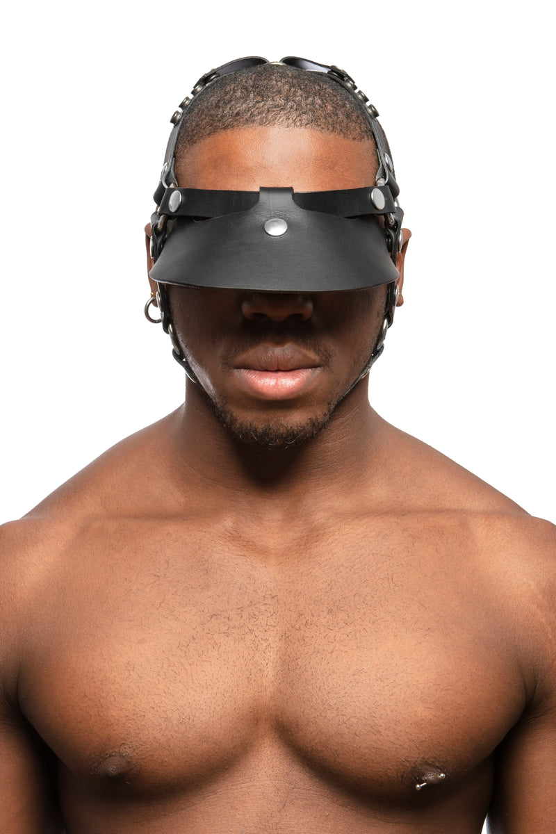  Model wearing black leather head harness and visor with stainless steel hardware. Front view.